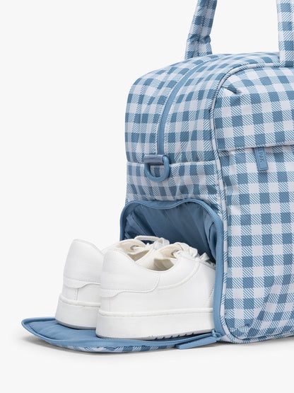 Shoe compartment of CALPAK Luka Duffel in white and blue gingham print in French Blue Gingham; DSM1901-FRENCH-BLUE-GINGHAM