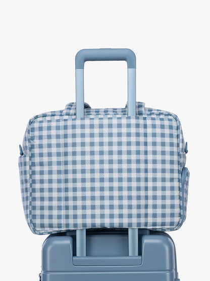 Luggage trolley sleeve of CALPAK Luka Duffel in white and blue gingham print in French Blue Gingham; DSM1901-FRENCH-BLUE-GINGHAM