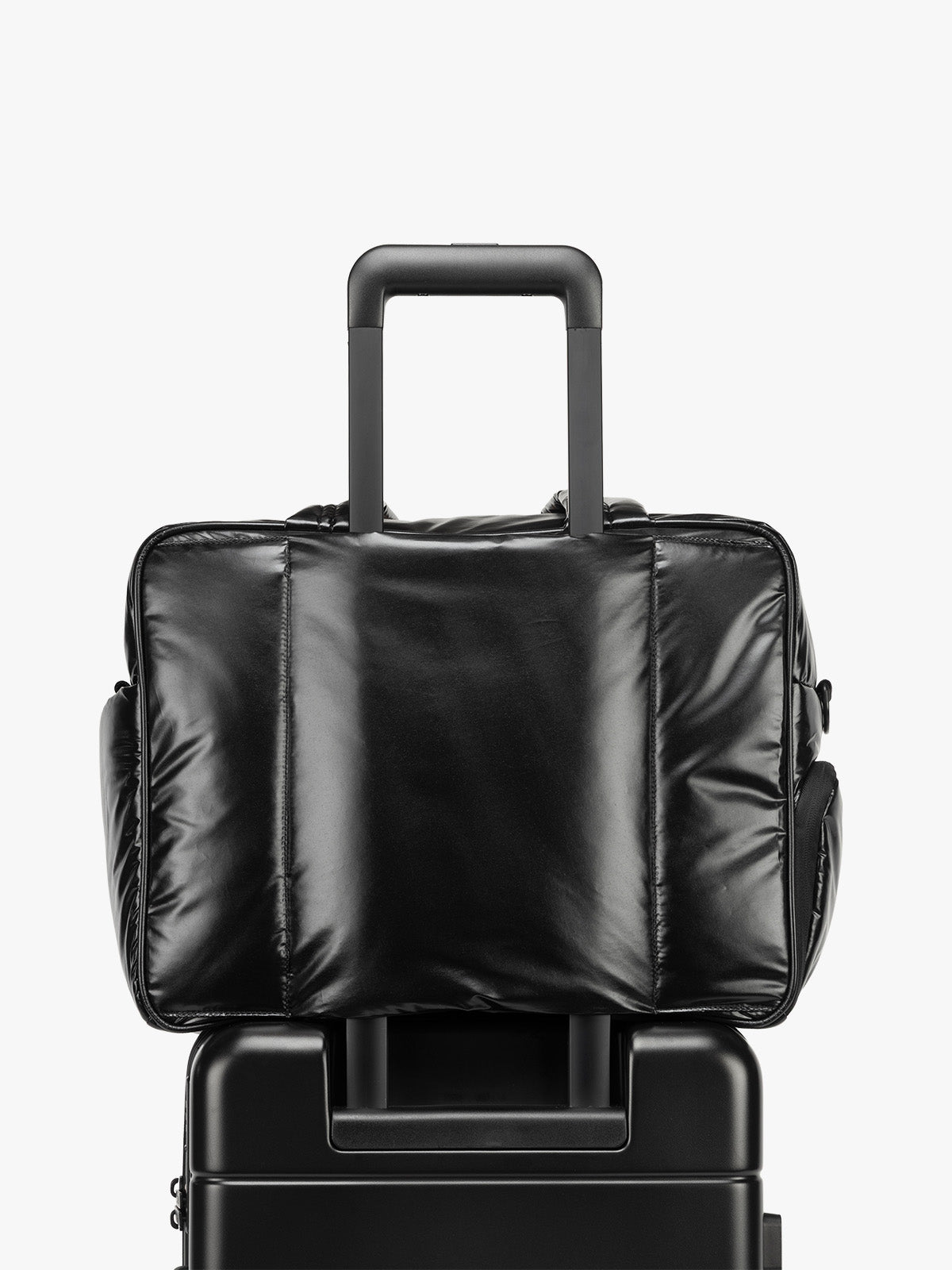 CALPAK Luka Duffel in shiny black on a white background with luggage sleeve; DSM1901-GLAZED-BLACK