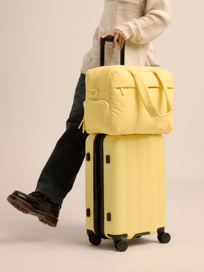 Butter CALPAK Luka Duffel Bag secured to Evry Carry-On Luggage by luggage trolley sleeve; DSM1901-BUTTER