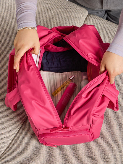 Model showing the monochrome dragonfruit pink interior of CALPAK luka duffel; DSM1901-DRAGONFRUIT