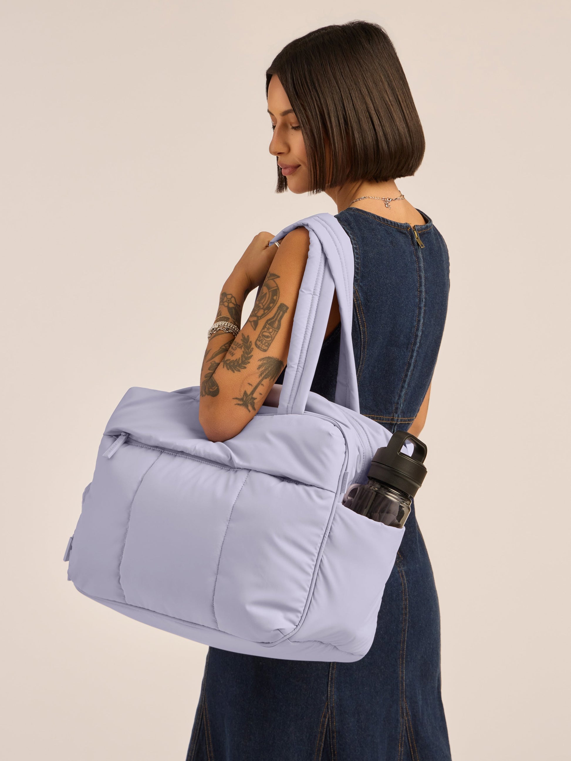 Model wearing CALPAK Luka Duffel monochrome purple lavender Orchid with straps; DSM1901-ORCHID