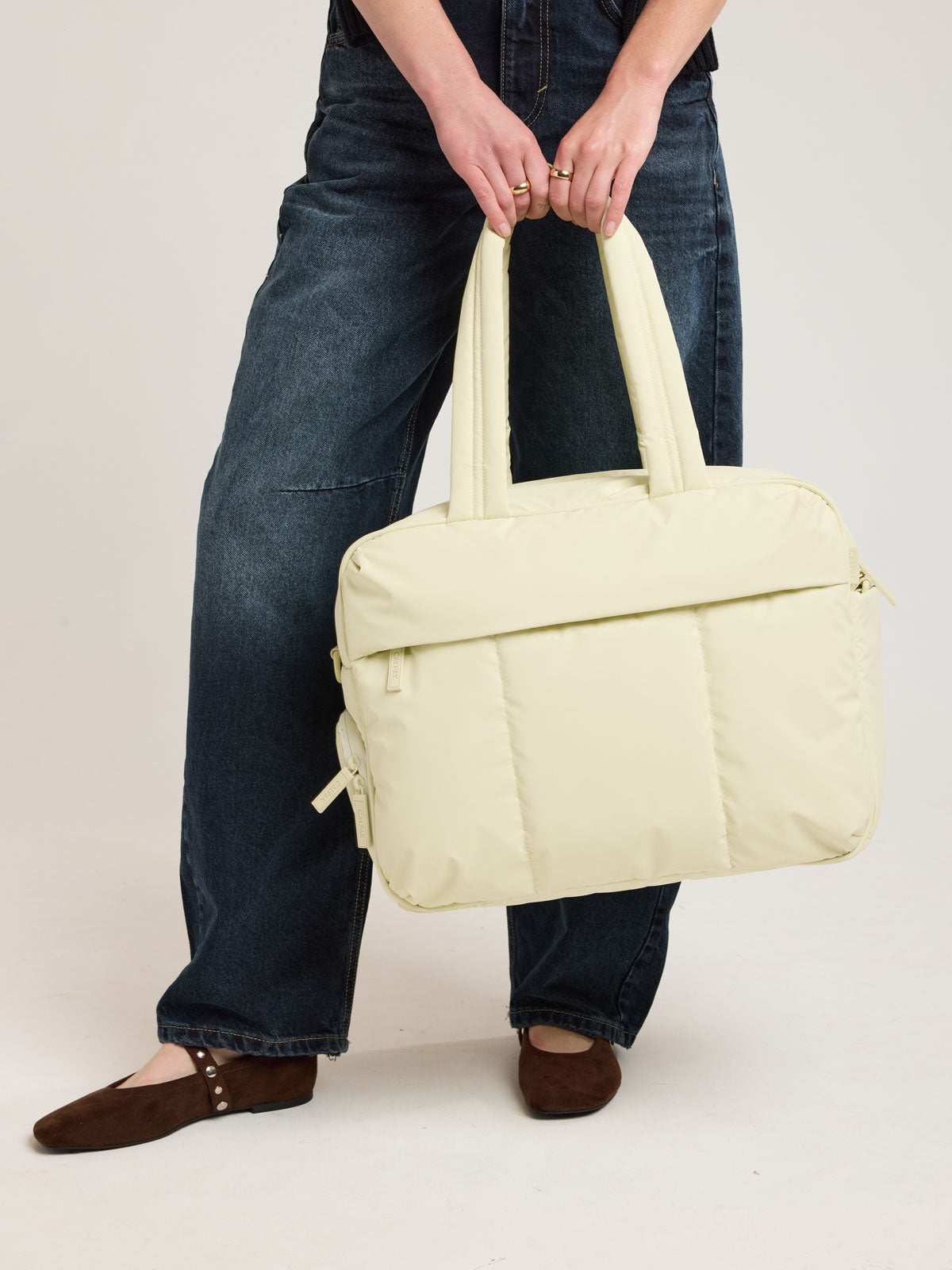 Person with CALPAK Luka Duffel in light green Celadon; DSM1901-CELADON