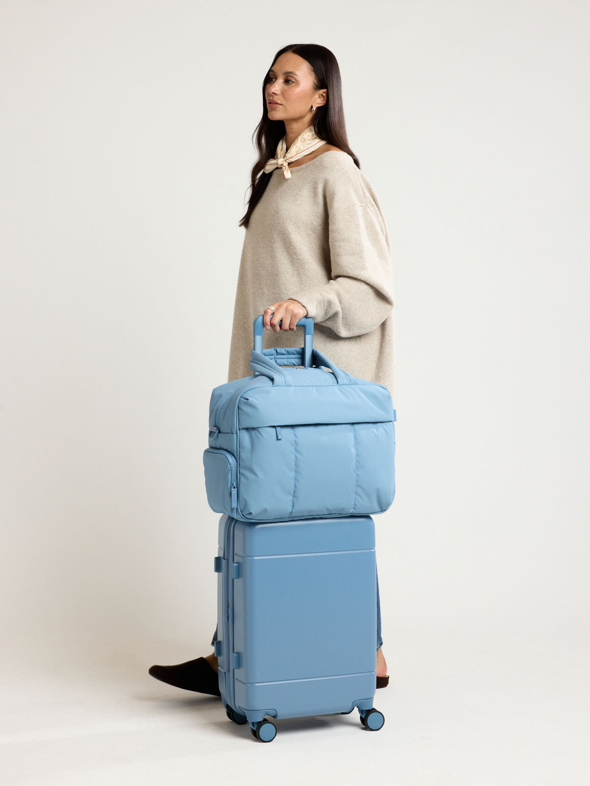 Woman with CALPAK Luka Duffel in light blue French Blue; DSM1901-FRENCH-BLUE