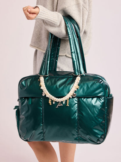 Woman carrying CALPAK  Luka Duffel in dark green shiny Glazed Kale with rope charm; DSM1901-GLAZED-KALE