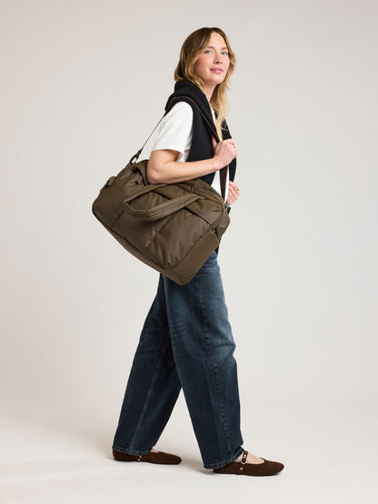 Person with CALPAK Luka Duffel in brown Mushroom; DSM1901-MUSHROOM
