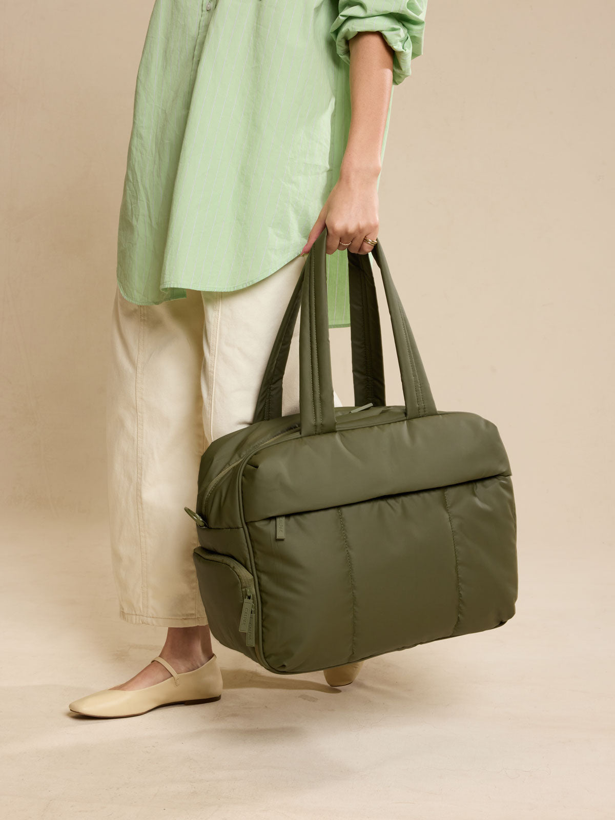 Model holding CALPAK Luka Duffel in dark green Pine; DSM1901-PINE