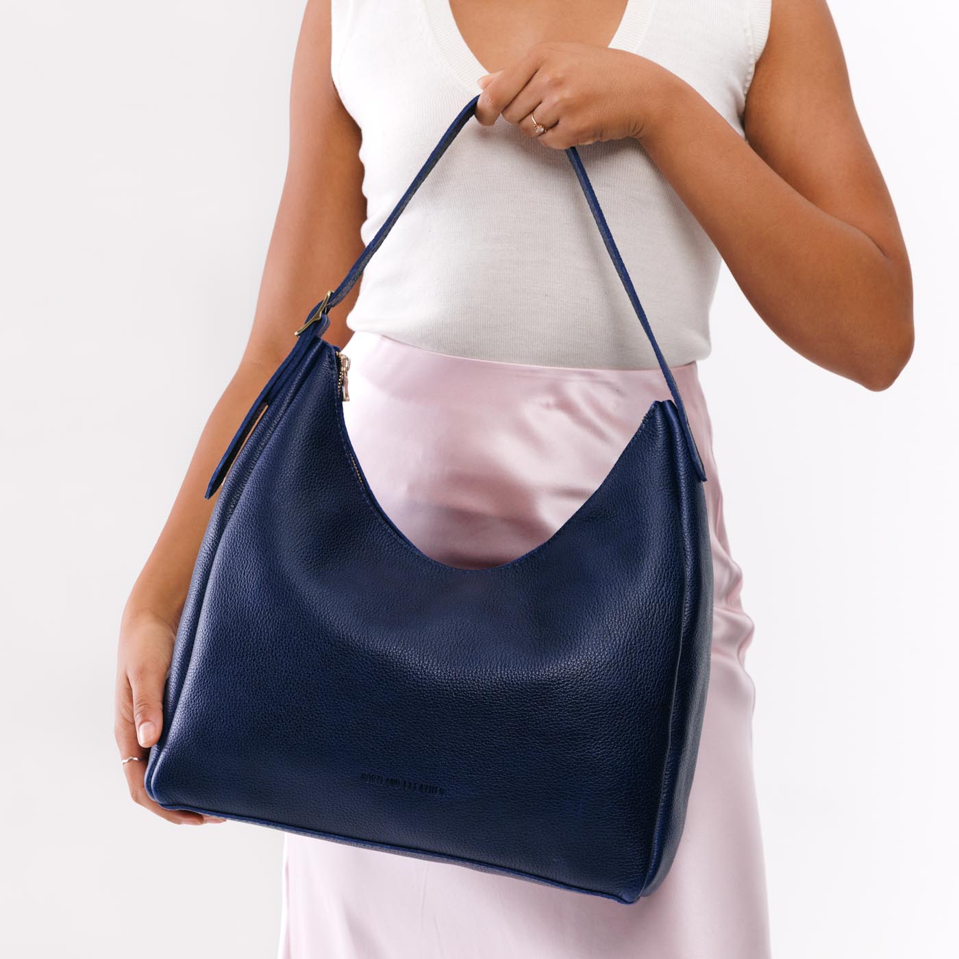 Cobalt*Large | Model holding u-shaped, flat-bottomed leather shoulder bag with adjustable strap
