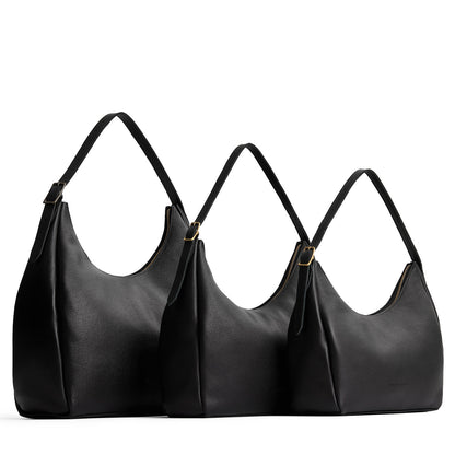 Pebbled--black | Size comparison image of oversized, large, and medium u-shaped, flat-bottomed leather shoulder bags with adjustable strap